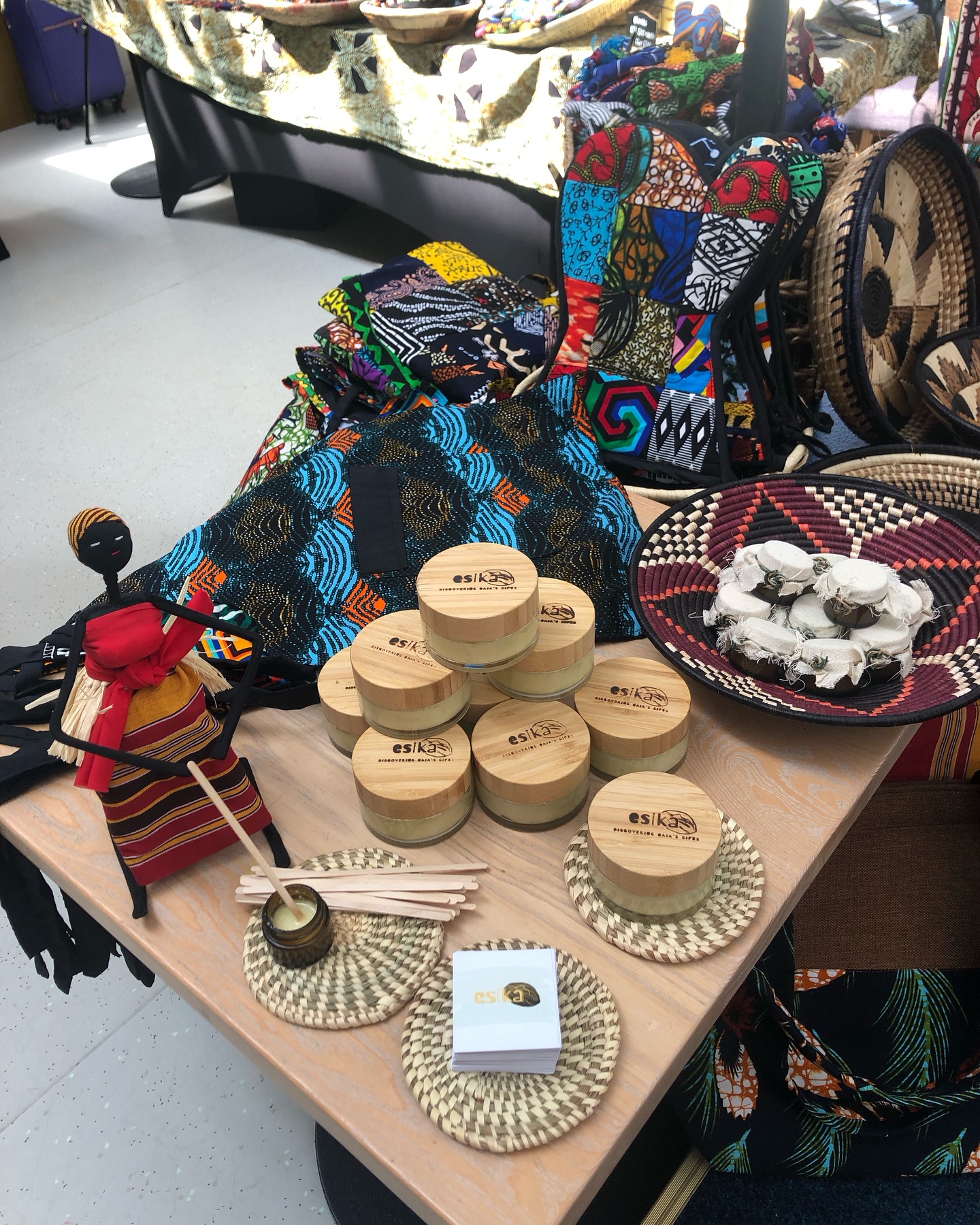 A vibrant community gathering in Lira with women and girls in colourful traditional dress, some in orange and blue, laughing and celebrating together